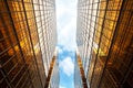 Upwards perspective of symmetrical contemporary skyscrapers, with blue sky and white clouds Royalty Free Stock Photo