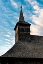 Upwards view of the bell tower of an old wooden church on a cloudy blue sunset sky in Maramures Royalty Free Stock Photo