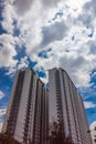 Upwards view of modern concrete apartment building against a beautiful blue sky with clouds. Stories vertical format Royalty Free Stock Photo