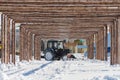 decorative arch made of wood on the central square of the city of Uralsk, a tractor cleans snow in the city,