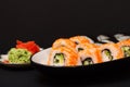 Uramaki California. Sushi rolls, plate with red pickled ginger and wasabi Royalty Free Stock Photo