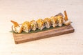 Uramaki dragon roll stuffed with fried gabardine prawns and orange fish roe and avocado