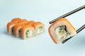 Uramaki. Philadelphia classic on blue background. Salmon, Philadelphia cheese, cucumber, avocado, tobiko. Japanese traditional Royalty Free Stock Photo