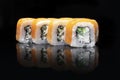 Uramaki. Philadelphia classic isolated on black background. Salmon, Philadelphia cheese, cucumber, avocado, tobiko Royalty Free Stock Photo