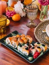 Uramaki rolls lie on a bamboo leaf on a rectangular dish on the table Royalty Free Stock Photo