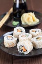 Uramaki sushi with carrot, cucumber, surimi and roasted white se