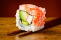 Uramaki sushi closeup on chopsticks Royalty Free Stock Photo