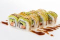 Uramaki tori sushi, a set of green rolls with sesame seeds and unagi sauce isolated on white. Eight pieces of sushi.