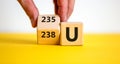 Uranium enrichment symbol. Hand turns the cube and changes the word `238 U` to `235 U`. Beautiful yellow, white background, co