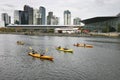 Kayak paddlers on Yarra River, South Wharf, Melbourne, Victoria, Australia. Coastal cityscape of skyscrapers in South Bank