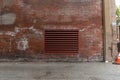 Urban alley alongside an old red brick industrial building with a large commercial HVAC exhaust vent, industrial background Royalty Free Stock Photo