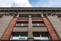 Urban architecture. Architectural detail. Low angle view to upper part of brick building facade. Royalty Free Stock Photo