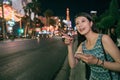 Urban Asian girl using phone walking on street