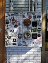 Urban Background: Electric Meter with Graffiti Stickers on White Brick Wall.