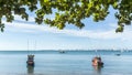 Two little fishing boats on an urban beach and city in the background. Royalty Free Stock Photo