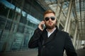 Urban business man in sunglasses talking smart phone traveling walking outside Royalty Free Stock Photo