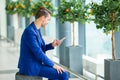 Young man with cellphone at the airport while waiting for boarding. Casual young boy wearing suit jacket. Royalty Free Stock Photo