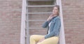 Urban chic: stylish woman seated on staircase in denim and bold colors