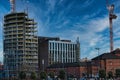 Urban construction site with cranes and developing high-rise building against a blue sky with wispy clouds in Liverpool, UK Royalty Free Stock Photo