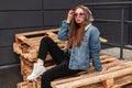 Urban cool young stylish hipster woman in trendy casual youth clothes in fashionable purple glasses poses in the city.  Glamorous Royalty Free Stock Photo