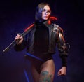 Urban and cyberpunk styled woman assassin with sword posing in studio