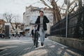 Urban cyclist with a bicycle walking through city streets Royalty Free Stock Photo