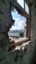 Urban decay: broken window with scenic sky view in abandoned building Royalty Free Stock Photo