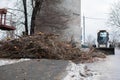 Urban emergency service removes a fallen tree on a road with special equipment tractor