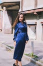 Urban fashion portrait of a stylish young business woman in a long blue dress and with long hair. Royalty Free Stock Photo