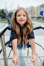 Urban fashion portrait of a teenage girl in the street at the railing on the stairs. Royalty Free Stock Photo