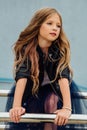 Urban fashion portrait of a teenage girl in the street at the railing on the stairs. Royalty Free Stock Photo