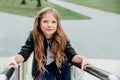 Urban fashion portrait of a teenage girl in the street at the railing on the stairs. Royalty Free Stock Photo