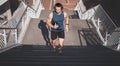 Urban fitness, man running on stairs and listening to music on headphones on outdoor exercise in Los Angeles. Health Royalty Free Stock Photo