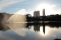Urban forest park with lake and fountains with city in the background Royalty Free Stock Photo