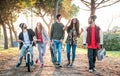 Urban friends gang walking in city skatepark on sunset backlight - Youth and millenial friendship concept