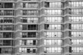 Urban geometry. Rows of large windows with various curtains, shutters, blinds, jalousies in a bricky wall of residential