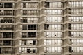 Urban geometry. Rows of large windows with various curtains, shutters, blinds, jalousies in a bricky wall of residential