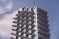 Urban geometry. Top of a high-rise residential building with glassy walls and squares of balconies making a pattern in Royalty Free Stock Photo