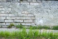 Urban grunge wall texture and green grass background