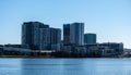 Urban high rise apartment condominiums community set on riverbank against blue sky