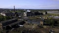Urban industry from drone. Action. A view from a height to the outskirts with tall chimneys from where smoke comes out.
