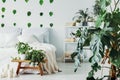 Fashionable bedroom interior with white wooden shelf with books and king size bed with white bedding