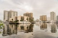 Urban Landscape in Aventura waterway with skies, water, boat, reflections and buildings