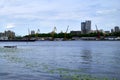 the urban landscape and the background of the river are multi-storey buildings, port cranes and cargo ships