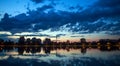 Urban landscape, cityscape buildings under construction on background of lake and sunset dramatic sky Royalty Free Stock Photo