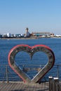 Urban landscape with a metal heart on the background of the sea.