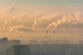 Urban landscape smoked polluted atmosphere from emissions of plants and factories, view of pipes with smoke and residential apartm Royalty Free Stock Photo