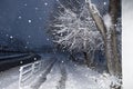 Urban landscape of a snowy street. Snow-covered morning road and pedestrian alley in snowfall. Winter weather conditions Royalty Free Stock Photo