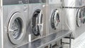 Urban laundry room with aligned washers in bright space and tiled wall interior Royalty Free Stock Photo
