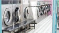 Urban laundry room with aligned washers in bright space and tiled wall interior Royalty Free Stock Photo